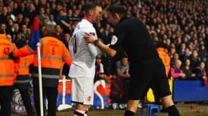 Wayne Rooney informuje sędziego o rzucanych z trybun monetach