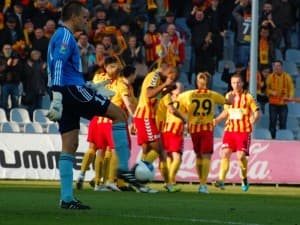 Łukasz Sapela, a w tle zawodnicy Korony Kielce